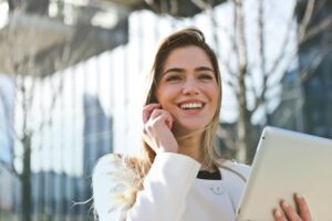 「笑顔でスマートフォンを使うビジネスウーマン」