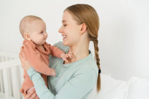 赤ちゃんを抱っこして微笑む母親｜子どもの健康と成長を見守る
