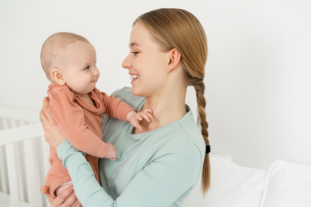 赤ちゃんを抱っこして微笑む母親｜子どもの健康と成長を見守る