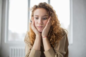 矯正治療の費用に悩む女性が考え込む様子｜こうとうデンタルオフィス木場